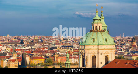 Wahrzeichen St. Nicholas katholische Kirche steht hoch über dem typischen roten Dächer und Kirchtürme der Mala Strana, Prag, Tschechische Republik Stockfoto