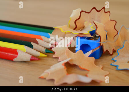 Farbstifte, Spitzer und Späne auf Holztisch. Geringe Schärfentiefe. Stockfoto