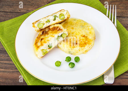Käse-Krapfen mit grünen Erbsen Stockfoto