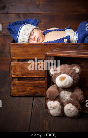 Süße kleine Neugeborene schläft in einer Holzkiste Stockfoto