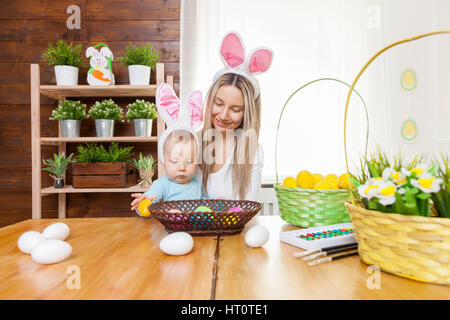 Ostern-Konzept. Glückliche Mutter und ihre niedlichen Kind trägt Hasenohren Vorbereitungen für Ostern Stockfoto