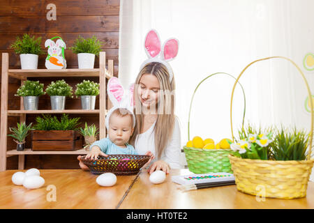 Ostern-Konzept. Glückliche Mutter und ihre niedlichen Kind trägt Hasenohren Vorbereitungen für Ostern Stockfoto