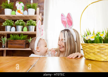 Ostern-Konzept. Glückliche Mutter und ihre niedlichen Kind trägt Hasenohren Vorbereitungen für Ostern Stockfoto