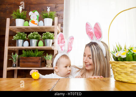 Ostern-Konzept. Glückliche Mutter und ihre niedlichen Kind trägt Hasenohren Vorbereitungen für Ostern Stockfoto