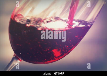 Glas vollmundigen Rotwein aus der Flasche gegossen wird Stockfoto