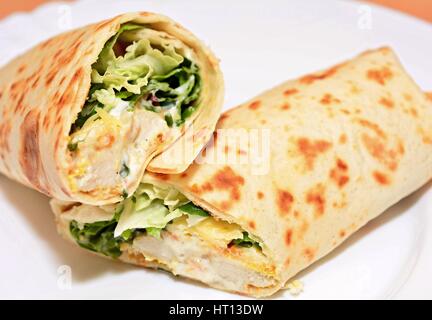 Tortilla wraps mit Hähnchen-Nuggets, frisches Gemüse und Salat. Stockfoto