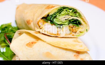 Tortilla wraps mit Hähnchen-Nuggets, frisches Gemüse und Salat. Stockfoto