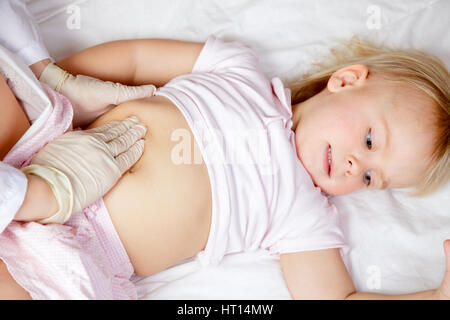 Prüfung des kleinen Mädchens Bauch mit manuelle Palpation Kinderarzt Stockfoto