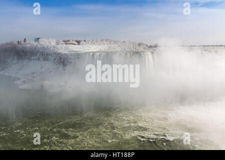 Niagara Falls auf der kanadischen US-Grenze im Winter.  Wolken von gefrorenen Spray in der Luft. Stockfoto