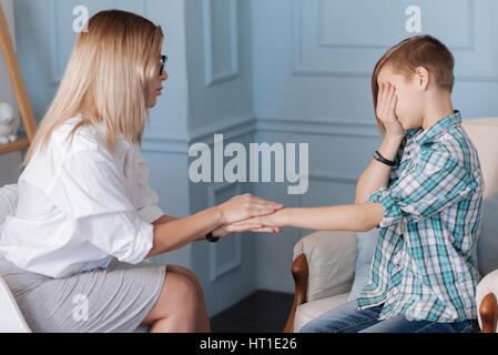 Macht nichts. Clevere Frauen intelligente Kleidung sitzen in Semi-Position während der Hand des Patienten in der Hand zu halten Stockfoto
