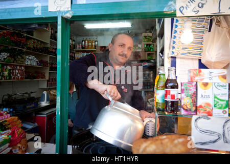 ISTANBUL, Türkei - 5. November 2009: Gießt Man Tee aus einem großen Kessel in einem Kiosk am Bahnhof Haydarpasa in Istanbul Stockfoto