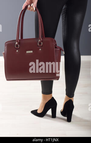 Modische Mädchen Leggings trägt und hält braune elegante Tasche Stockfoto