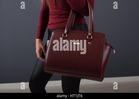 Modische Mädchen Leggings trägt und hält braune elegante Tasche Stockfoto