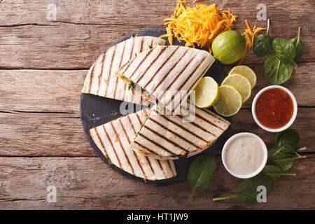 Mexikanisches Quesadilla mit Spinat, Bohnen und Cheddar Käse Nahaufnahme auf dem Tisch. horizontale Ansicht von oben Stockfoto
