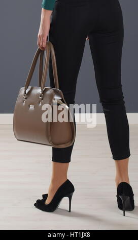 Modische Mädchen tragen Leggings und halten leichte braun elegante Tasche Stockfoto