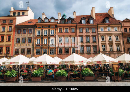 Warschau, Polen - 28. Mai 2015: Traditionelles Café mit Touristen gegen typische alte Häuser am alten Marktplatz in Warschau in einem Sommer Stockfoto