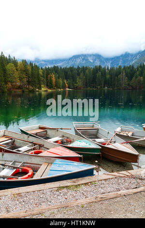 Wunderschönen Lago di Fusine Bergsee am Boot und Mangart Berg im Hintergrund in Nord-Italien, Alpen, Europa Stockfoto