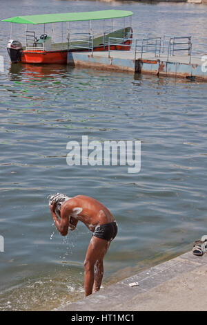 Nicht identifizierte Jugend Baden am Ghat, eine Reihe von Stufen führen hinunter zu Wasser, auf dem Pichola-See, Indien. Viele Menschen haben keine Hauswasserversorgung Stockfoto