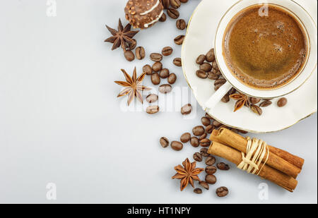 Tasse Kaffee Kaffeebohnen, Schokolade und Gewürzen umgeben. Stockfoto