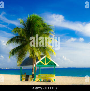 Mann sitzt in einer Hütte und blickt auf die Karibik am West Bay Beach, Grand Cayman, Cayman-Inseln Stockfoto