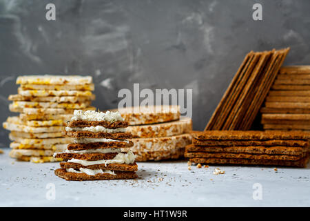 Brötchen mit Quark und Brot Rollen zum Frühstück auf einem Hintergrund Stapel von verschiedenen gesunden Knäckebrot, Ernährung, Vitamin-Snack. Stockfoto