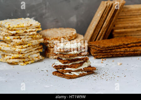 Brötchen mit Quark und Brot Rollen zum Frühstück auf einem Hintergrund Stapel von verschiedenen gesunden Knäckebrot, Ernährung, Vitamin-Snack. Stockfoto