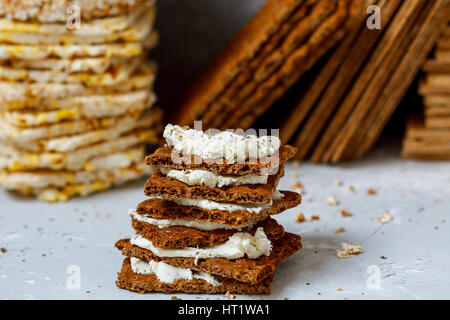 Brötchen mit Quark und Brot Rollen zum Frühstück auf einem Hintergrund Stapel von verschiedenen gesunden Knäckebrot, Ernährung, Vitamin-Snack. Stockfoto