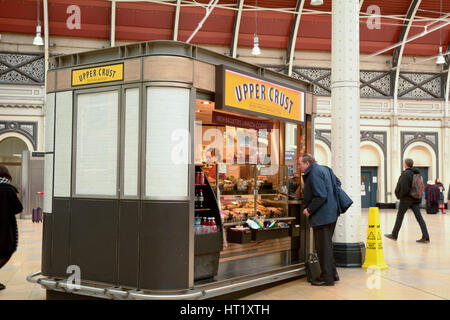 Mann etwas zu Essen für seine Zugfahrt von einem oberen Kruste Sandwich Essen Kiosk im Bahnhof Paddington in London England kaufen Stockfoto