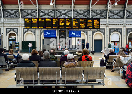 Passagiere, die an- und Abreise vom Bahnhof Paddington in London England - die Station hat eine Menge Abfahrts- und Ankunftszeiten Boards für info Stockfoto