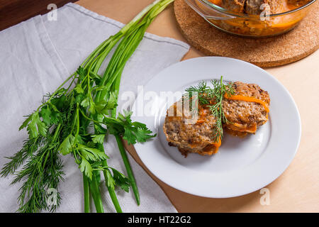 Frikadelle aus Schweinefleisch serviert auf einem weißen Teller und Kräuter - Dill, Frühlingszwiebeln, Petersilie um die Platte. Hausgemachte Frikadellen, gebraten mit Gemüse in Keramik Stockfoto