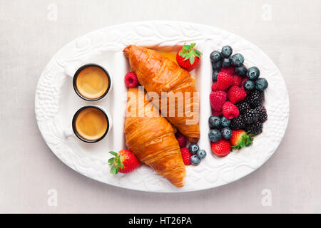 Sommer Frühstück auf einem Tablett. Frische reife Beeren, Gebäck und zwei Tassen Kaffee espresso Stockfoto