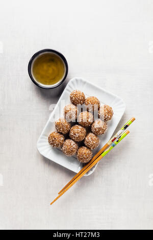 süße Häppchen aus Nüssen und Termine für Vegan hergestellt. Homemade bars gesunde Superfoods und Chinesische Essstäbchen und grüner Tee Stockfoto