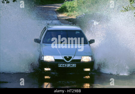 1989 Alfa Romeo 164 Fahrt durch eine Furt. Künstler: unbekannt. Stockfoto