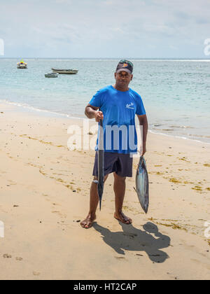 Tamarin, Mauritius - 8. Dezember 2015: Unidentified Fischer mit Trophäe Fisch in der Hand an der Tamarin Bucht auf Mauritius. Stockfoto