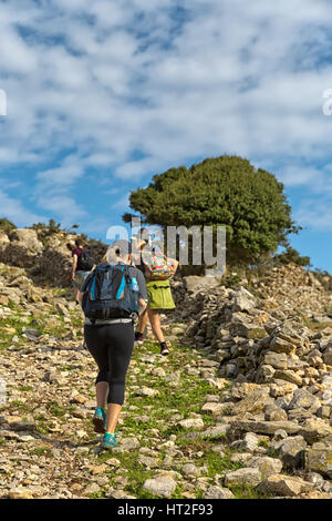 Frau in Gruppe Wandern, und bewundern Sie die wunderschöne Landschaft Blick auf die grünen Berge, Amorgos Island, Griechenland Stockfoto