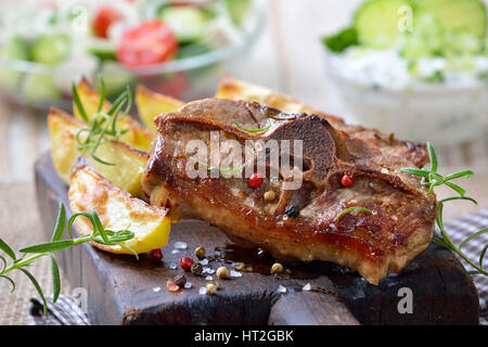 Griechisches Essen: gebratene Lammkoteletts mit gebackenen Kartoffelecken, Bauern Salat und Tzatziki Stockfoto