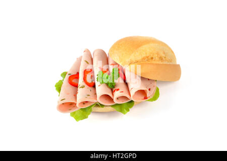 Frische Brötchen mit in Scheiben geschnittenen Paprika Wurst und ein Salatblatt auf weißem Hintergrund Stockfoto