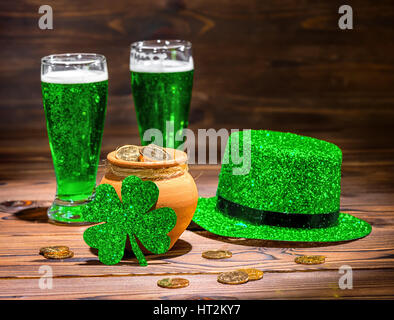 St. Patricks Day mit Gläsern Jungbier, Kleeblatt, Kobold Hut und Topf voll Gold Münzen auf Vintage Holz-Hintergrund, Nahaufnahme Stockfoto