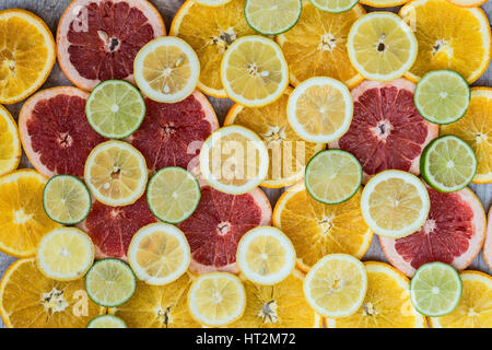 Zitrusfrucht-Hintergrund mit in Scheiben geschnittenen Orangen Zitronen Limetten und Grapefruit. Stockfoto