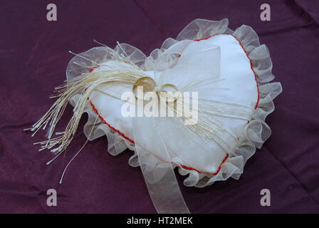 Weiße Hochzeit Kissen für Ringe auf Bräute Hände Stockfoto