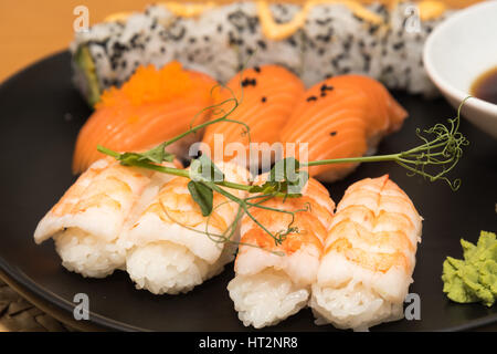 Nahaufnahme von einem Sushi-Mittagessen auf einer schwarzen Platte Stockfoto