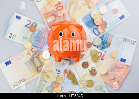 Piggy Bank beobachten einen Stapel von Euro-Banknoten und Münzen. Stockfoto