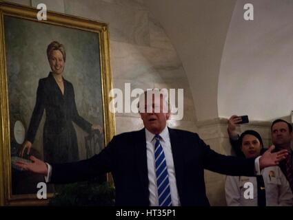 Washington, USA. 7. März 2017. US-Präsident Donald Trump grüßt die erste neue Besucher in die zentrale Halle im Erdgeschoss des weißen Hauses, vor der offiziellen Porträt der ehemaligen First Lady Hillary Clinton, Washington, DC, 7. März 2017. Bildnachweis: MediaPunch Inc/Alamy Live-Nachrichten Stockfoto
