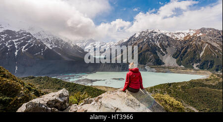 Wanderer, die sitzen auf Felsen, Blick ins Tal von Sealy Gebirgsseen Rennstrecke, Gletscherseen Mueller Lake und Lake Hooker Hooker Stockfoto