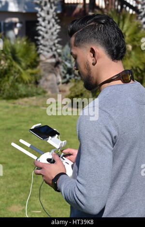 Lizenzierte Drohne Piloten fliegen DJI Phantom 4 Drohne mit einem Gimbal und Kamera angebracht.  Drohne, Fotografie, Video, fliegen, Überwachung. Stockfoto