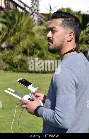 Lizenzierte Drohne Piloten fliegen DJI Phantom 4 Drohne mit einem Gimbal und Kamera angebracht.  Drohne, Fotografie, Video, fliegen, Überwachung. Stockfoto