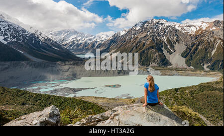 Wanderer, die sitzen auf Felsen, Blick ins Tal von Sealy Gebirgsseen Rennstrecke, Gletscherseen Mueller Lake und Lake Hooker Hooker Stockfoto