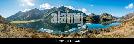 Wanderer stehen auf Felsen, Berge im Lake Moke Lake in der Nähe von Queenstown, Otago Region und Southland, Neuseeland Stockfoto