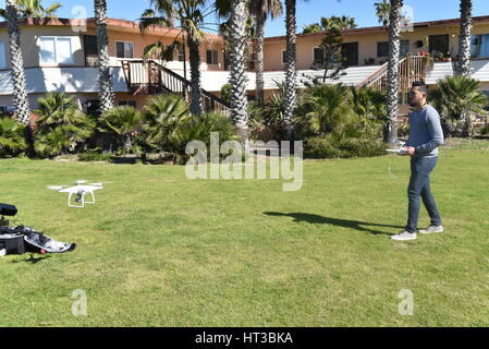 Lizenzierte Drohne Piloten fliegen DJI Phantom 4 Drohne mit einem Gimbal und Kamera angebracht.  Drohne, Fotografie, Video, fliegen, Überwachung. Stockfoto