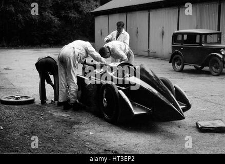 Mechaniker arbeiten an Leon Cushmans Austin 7 Racer für einen Geschwindigkeits-Weltrekord Versuch, Brooklands, 1931. Künstler: Bill Brunell. Stockfoto